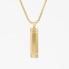 Gold plated cylinder urn necklace on a white background
